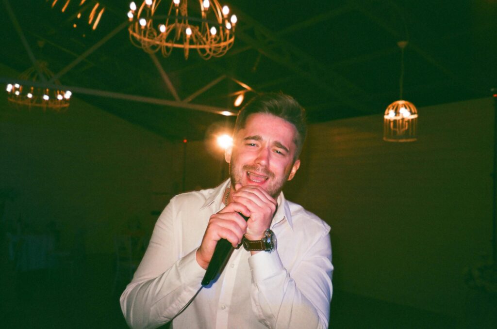 Man singing with a microphone at an indoor event