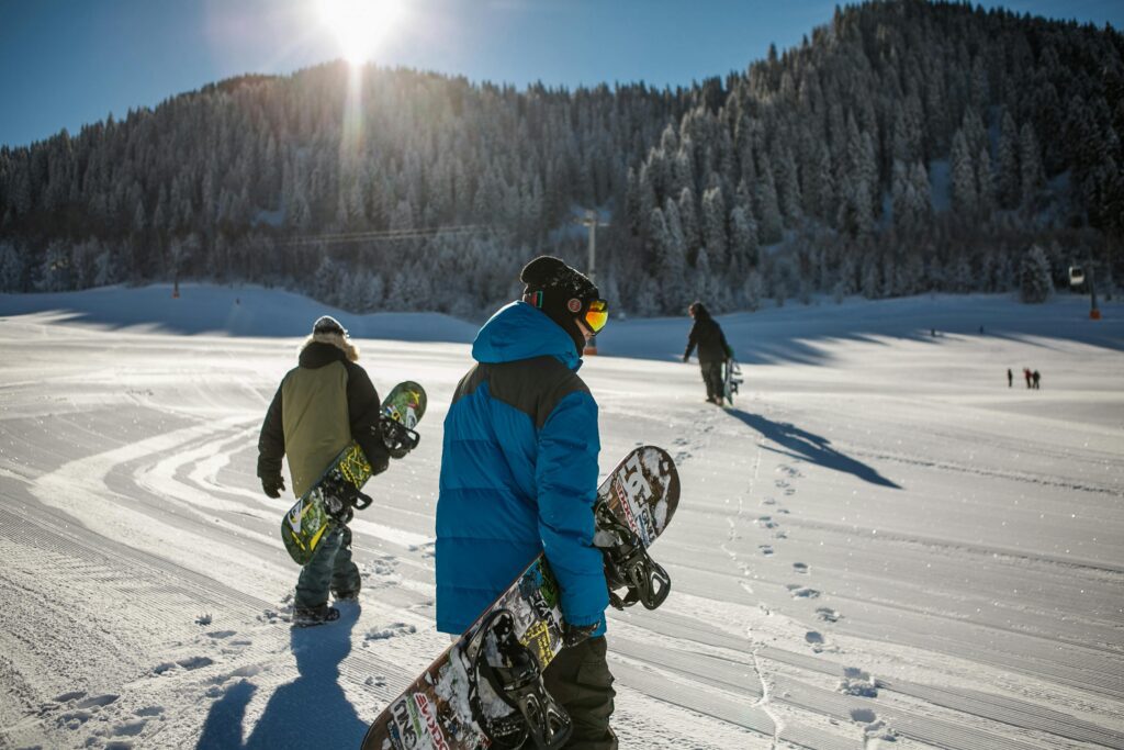 Group of snowboarders walking on snowy mountain slope