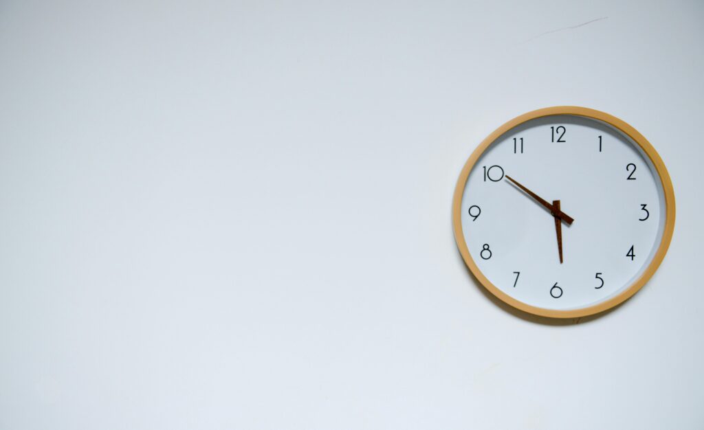 Wall clock showing 5:50 as a symbol of time tracking, scheduling, and workplace productivity.