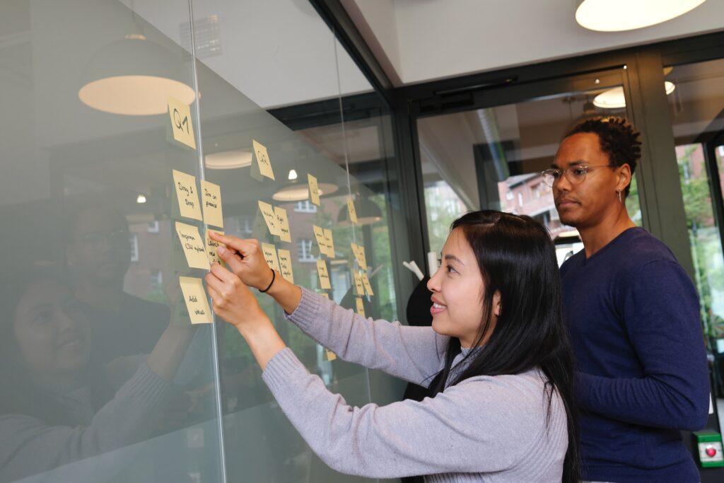 two employees at their annual planning meeting mapping out ideas with sticky notes