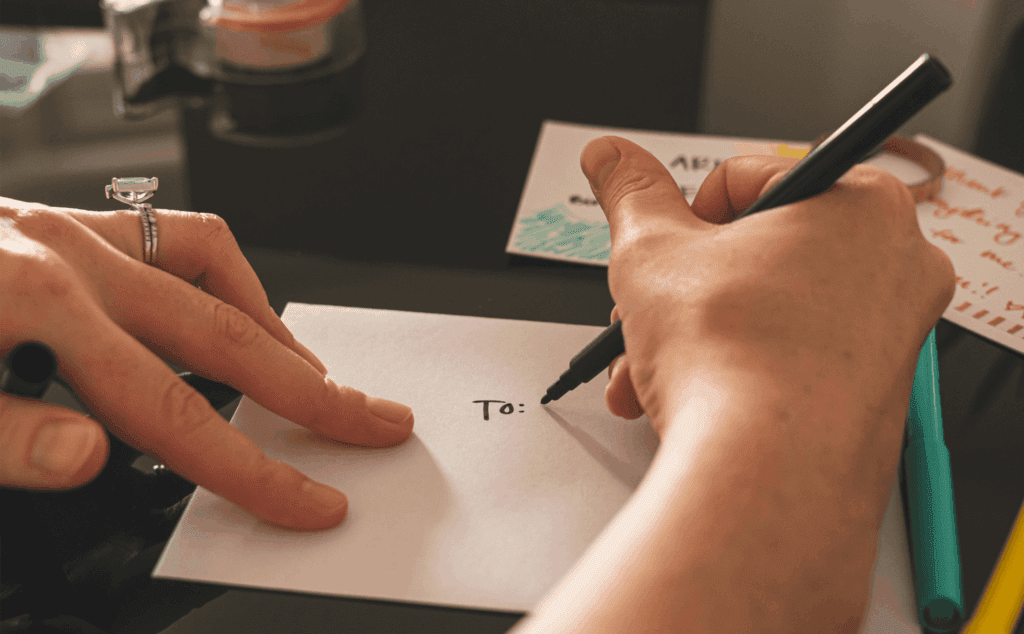 Person writing a message on an envelope for gifting or correspondence