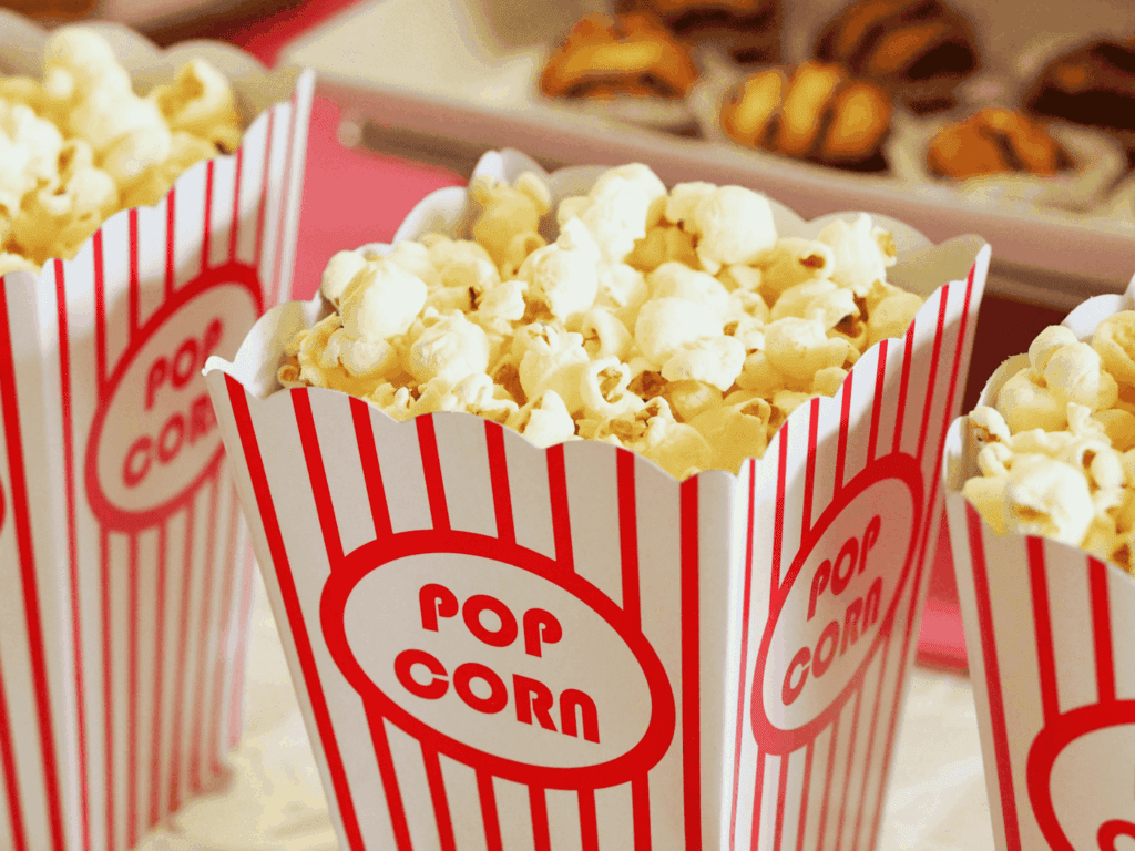 Freshly popped popcorn in classic striped boxes, perfect for movie night or office snack breaks