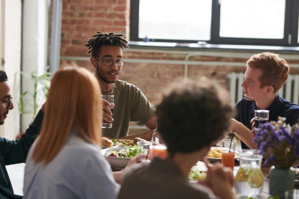 Diverse group of friends enjoying food and conversation around a dining table