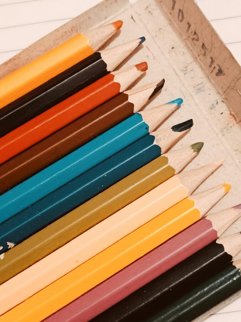 Close-up of colorful pencils neatly arranged in a box, ready for creative work