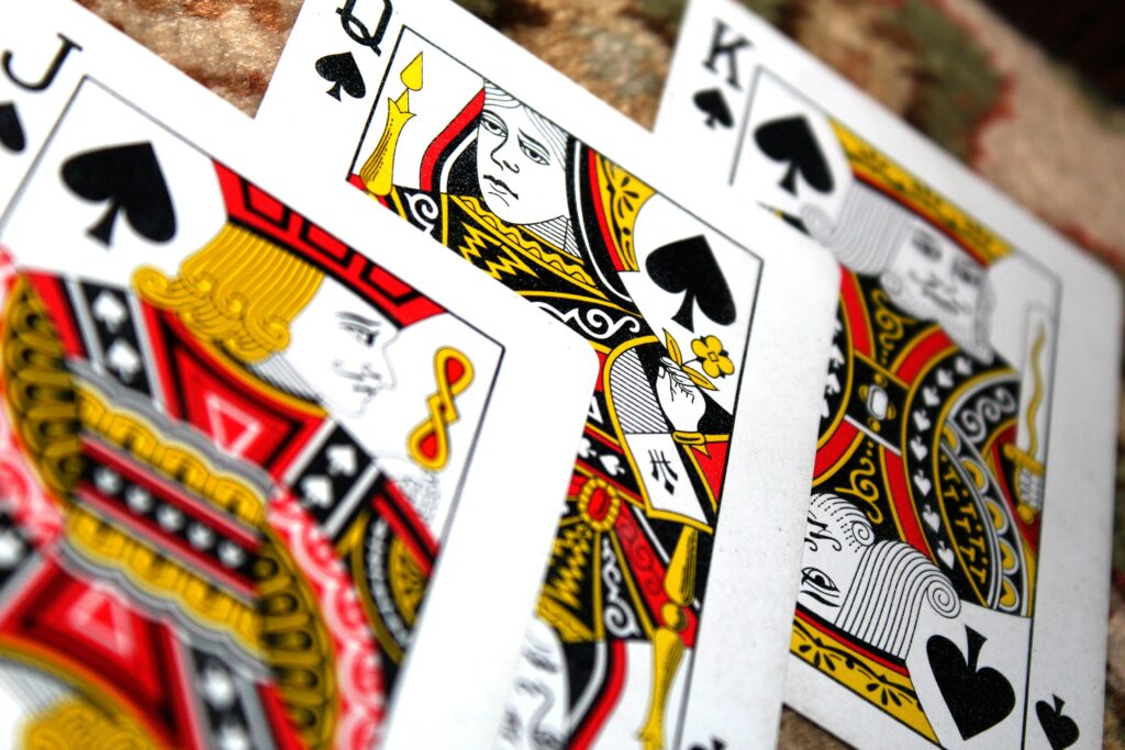 Close-up of playing cards Jack, Queen, and King of Spades in a poker hand