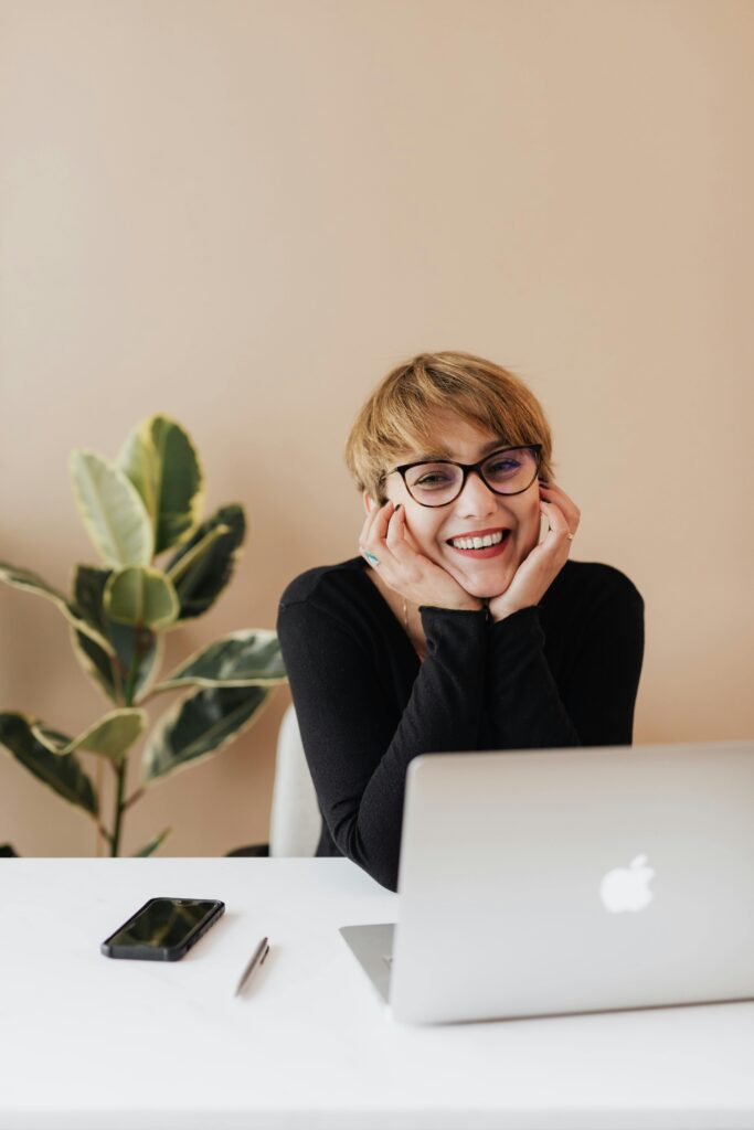 Smiling professional working from home on a laptop, creating a positive and productive home office vibe