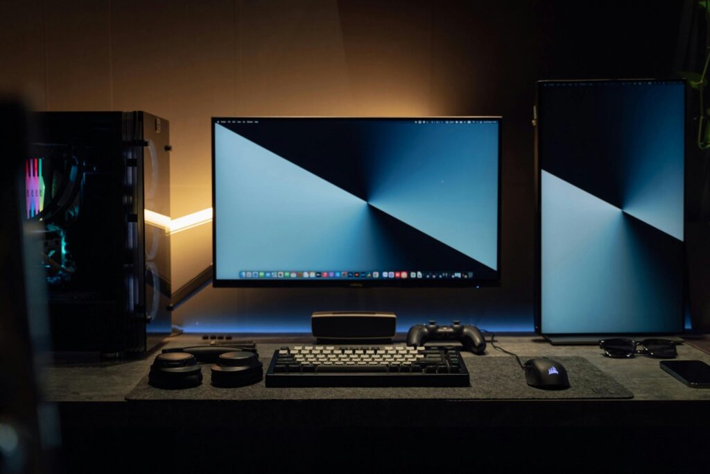 Modern dual monitor gaming and work setup with mechanical keyboard, mouse, and PC tower.