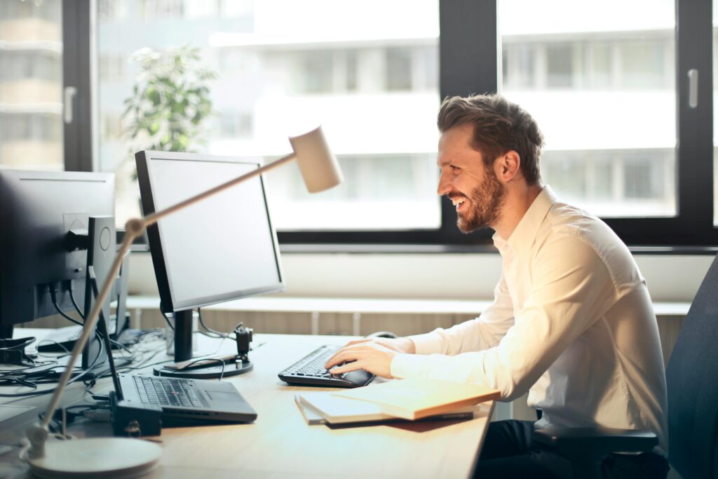 Smiling businessman working at his desk on a computer in a modern office