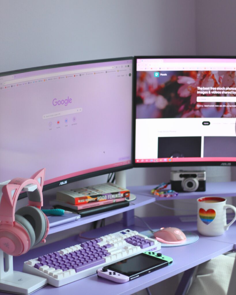 Modern home office setup with dual monitors, pastel accessories, and a cozy workspace for productivity and creativity