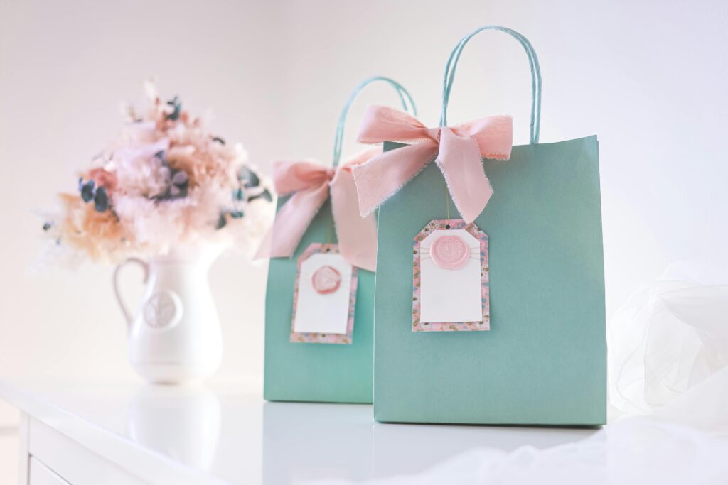 Elegant pastel gift bags with pink bows and tags, perfect for staff appreciation 