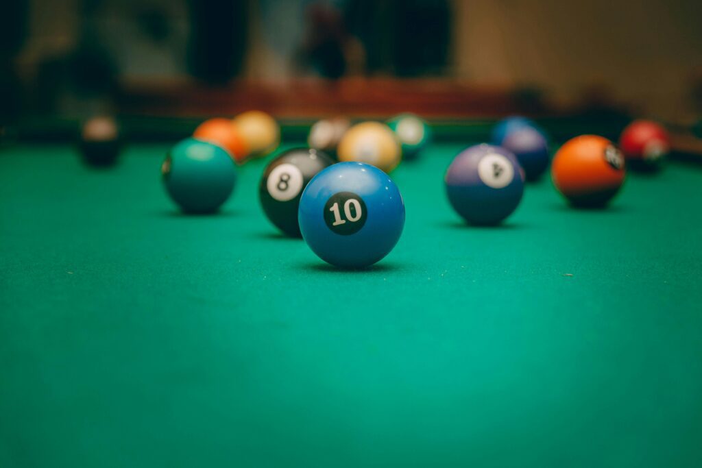 Close-up of billiard balls on a pool table, highlighting the blue number 10 ball in focus