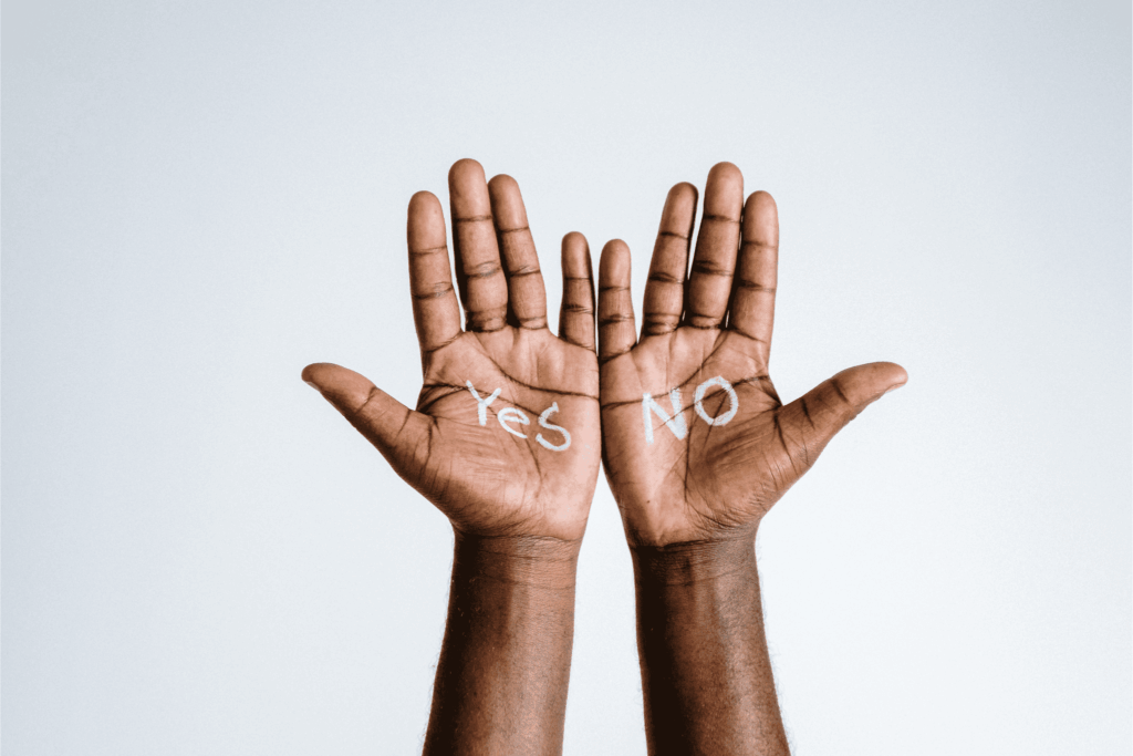 Close-up of hands with 'Yes' and 'No' written on palms, symbolizing decision making and choices