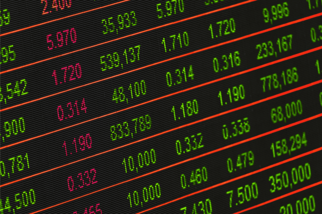 Digital stock market board displaying numbers in green and red with trading values and price changes.