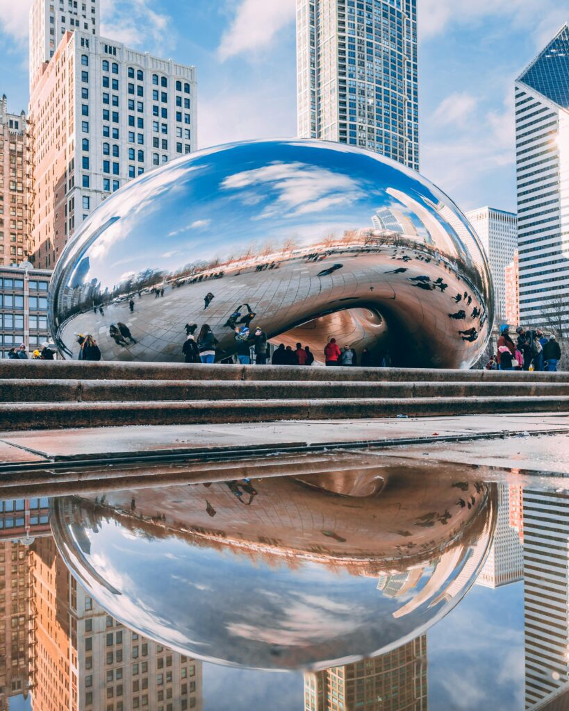 Cloud Gate sculpture, also known as The Bean, reflecting the Chicago skyline and visitors in Millennium Park.
