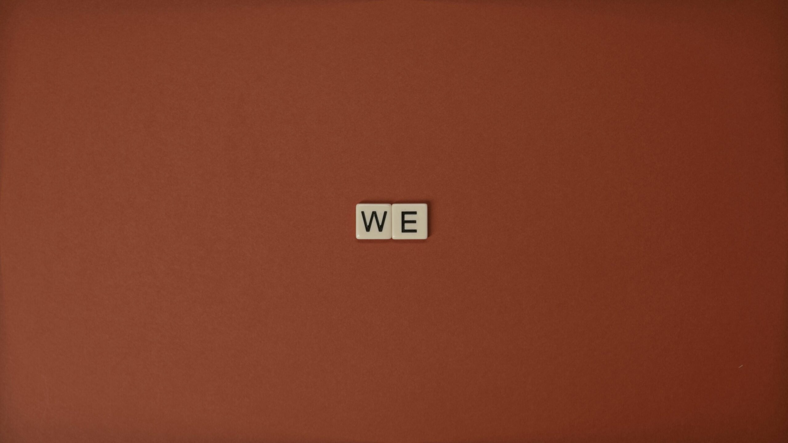 Scrabble pieces spelling out the word "we", signaling teamwork and unity
