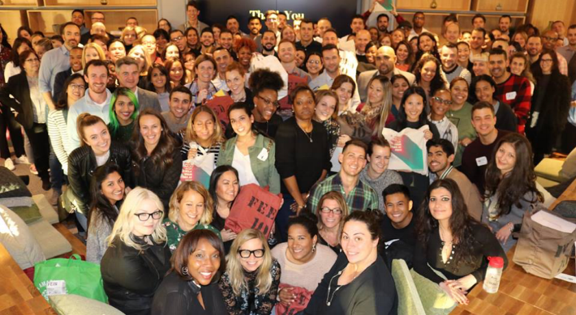 A large group of employees posing for a team photo after a kick-off event
