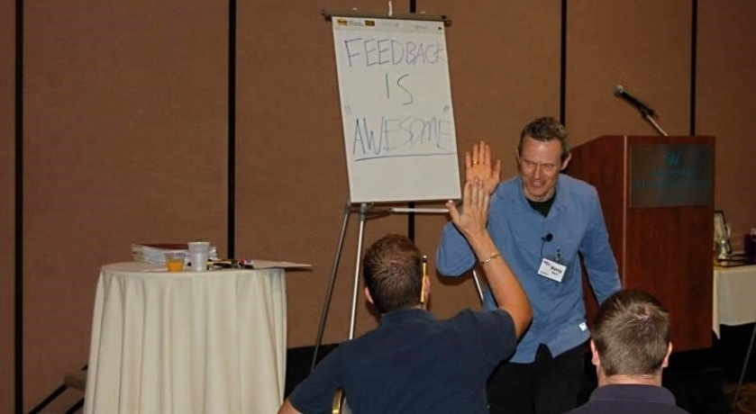 A facilitator collecting feedback from attendees during a kick-off meeting