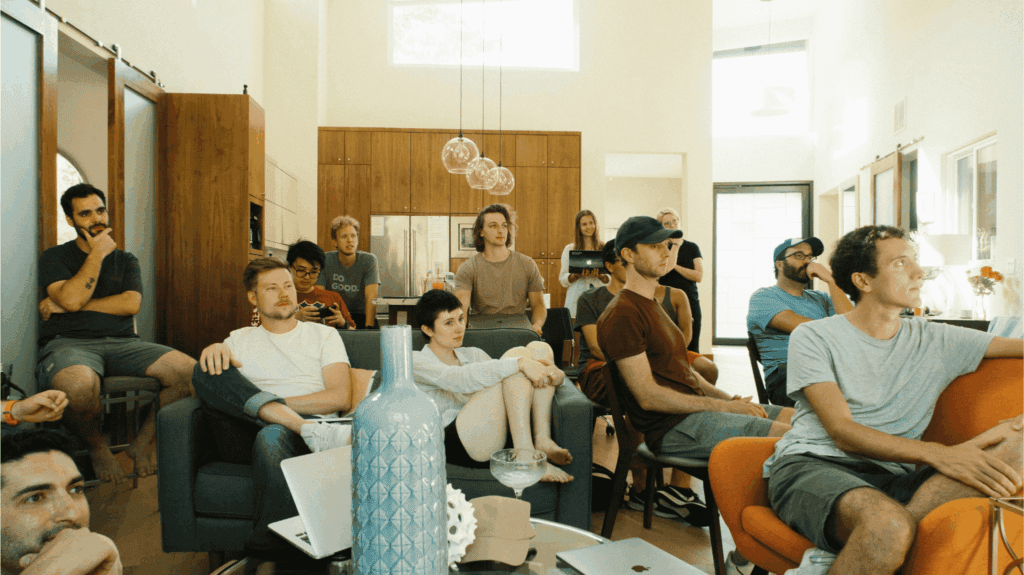 A group of colleagues attentively listening during a large team meeting in a modern office space