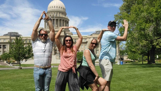 4 people outside of a building striking a pose