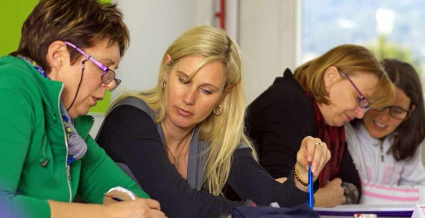 People leaning over a table studying